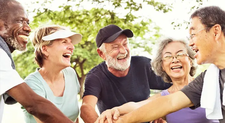 A group of people laughing together in the park.