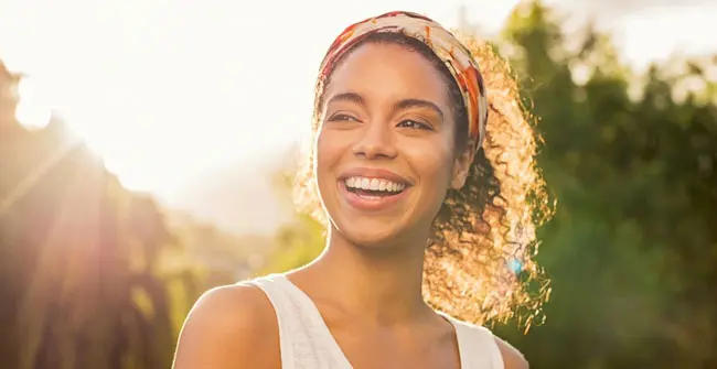 A woman with a headband smiles for the camera.