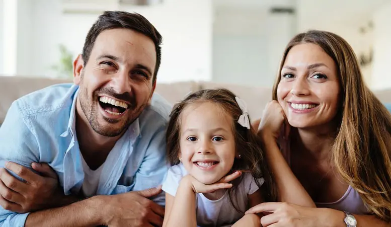 A family of three smiling for the camera.